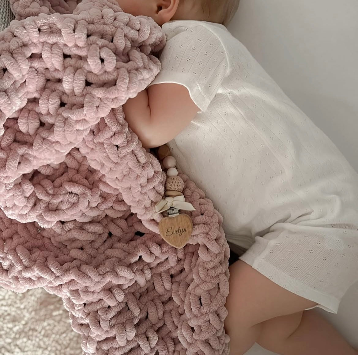 Child wrapped in a pink chenille blanket 